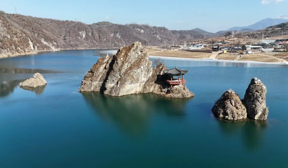 Panoramic view of 도담삼봉 in Danyang, South Korea, with three iconic rock peaks rising from the river surrounded by lush mountains.