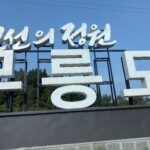 Entrance sign of Mureungdowon in Yeongwol, Gangwon Province, set against a clear blue sky.